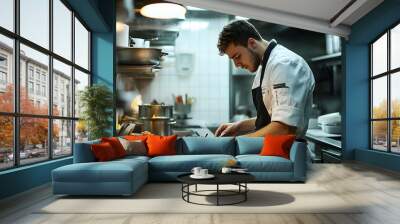 Candid photo of a young male chef preparing food in a restaurant kitchen, displaying culinary expertise and passion, ensuring delicious and high-quality dishes for patrons to enjoy,  Wall mural